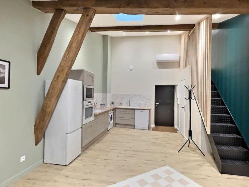Il comprend une cuisine avec un escalier et un réfrigérateur blanc. dans l'établissement Le Jardin Mâconnais de Miss K, à Mâcon