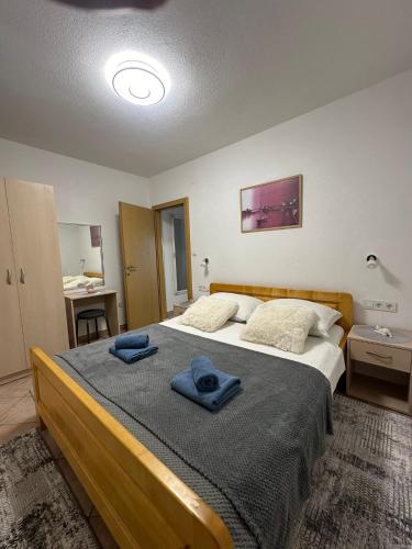 a bedroom with a large bed with two towels on it at Apartman Majba 2 in Zaglavice
