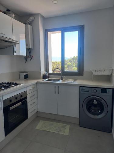 a kitchen with a sink and a washing machine at Soleil & Compagnie Cabo Huerto in Cabo Negro