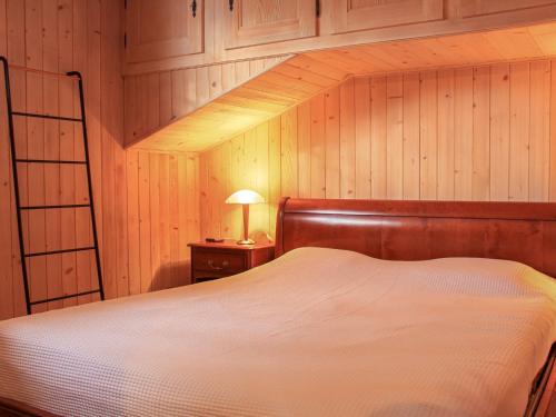 a bedroom with a white bed and a wooden wall at Apartment Muscardin 5-6 by Interhome in Chesières