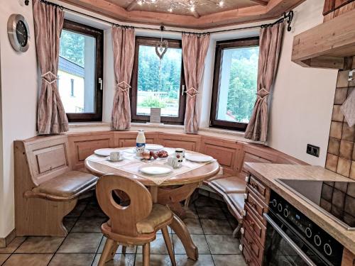 a kitchen with a table and chairs and windows at Holiday Home zur schönen Aussicht by Interhome in Wörgl