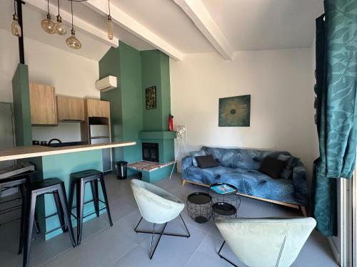 un salon avec un canapé bleu et une cuisine dans l'établissement Charmant appartement T2 au coeur des vignes, à Cogolin