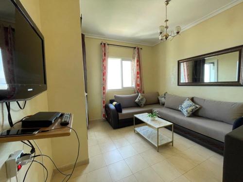 a living room with a couch and a flat screen tv at Bella Vista Cabo Negro-vue sur mer in Cabo Negro