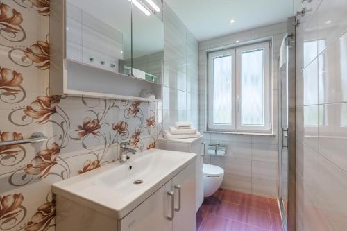 a white bathroom with a sink and a toilet at Pogacar Apartments in Bled