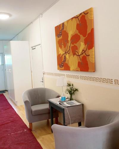 a room with two chairs and a table and a painting at Ollinpolun matkakoti in Sulkava