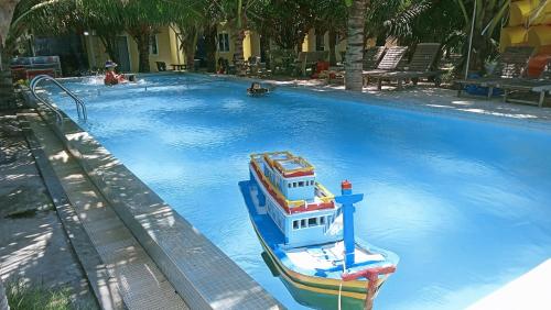 a boat in the water in a swimming pool at Biển Ngọc Homstay in Ấp Sung Xuân