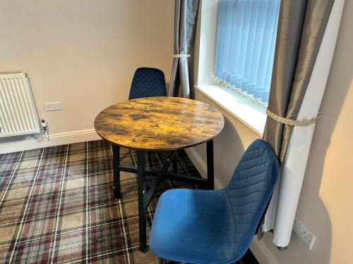 a table and two chairs next to a table and a window at The Prince Albert Pub & Hotel with onsite FREE PARKING 2 minutes from Legoland in Windsor