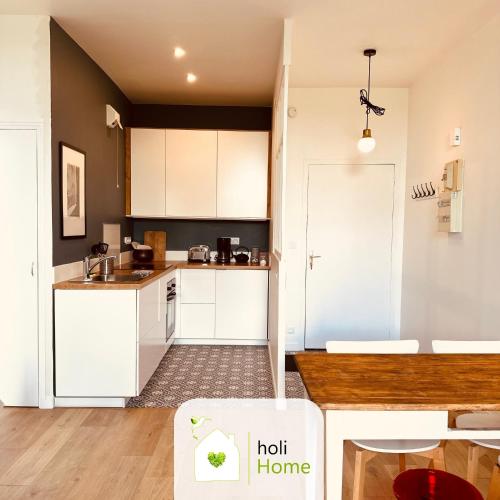 une cuisine avec des armoires blanches et un comptoir dans l'établissement H5 Bel appartement proximité gare et centre-ville, à Vitré