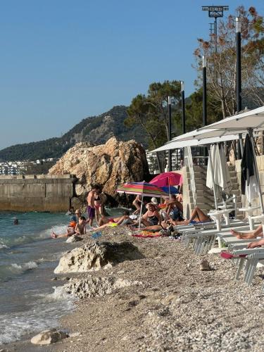 a group of people sitting on a beach at Seaside Residence in Vlorë