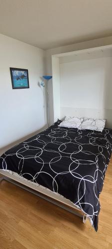 une chambre avec un lit avec une couette noire et blanche dans l'établissement Terrasse sur le lac, à La Rochelle