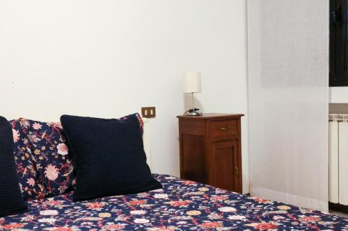 a bed with two pillows and a lamp on a table at Gioiella, pool & lake in Desenzano del Garda