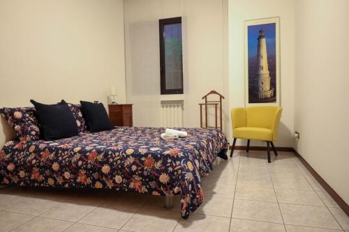 a bedroom with a bed and a yellow chair at Gioiella, pool & lake in Desenzano del Garda