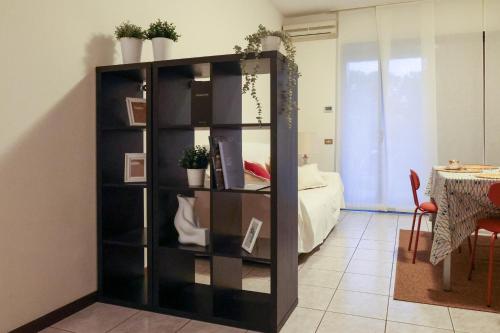 a black book shelf in a room with a bed at Gioiella, pool & lake in Desenzano del Garda
