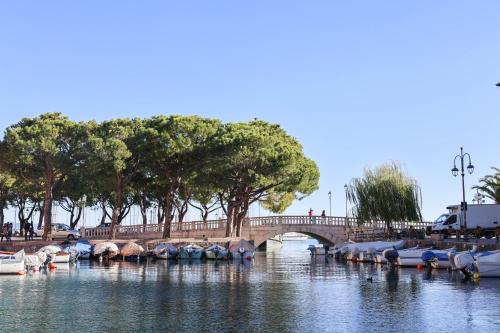 a bridge over a river with boats in the water at Gioiella, pool & lake in Desenzano del Garda