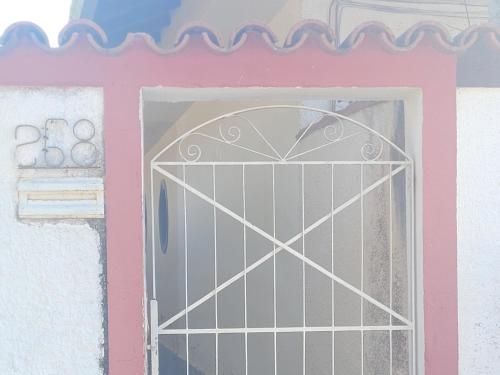 a door in a pink and white building with a window at Casa aconchegante no Centro da Cidade - Cantinho da Bia MP in Miguel Pereira