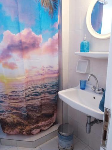a bathroom with a shower curtain with a sink at Yacht Front Studio - No 4 in Ios Chora