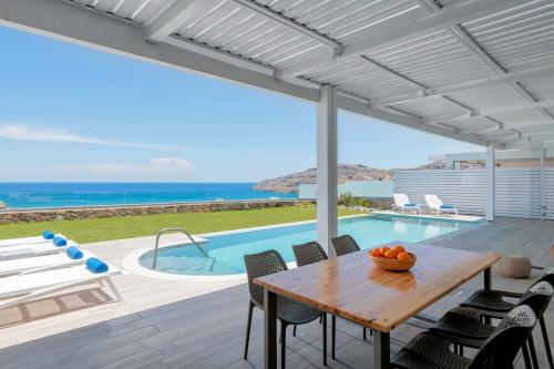 a dining room with a table and a view of the ocean at Executive Rhodes Villa Villa Akrotiri Stunning Sea Views 3 Bedrooms Lindos in Líndos