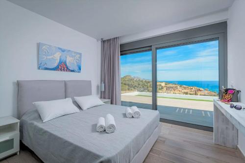 a bedroom with a bed with a view of the ocean at Executive Rhodes Villa Villa Akrotiri Stunning Sea Views 3 Bedrooms Lindos in Líndos