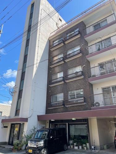 a black suv parked in front of a building at Base605 in Kurume