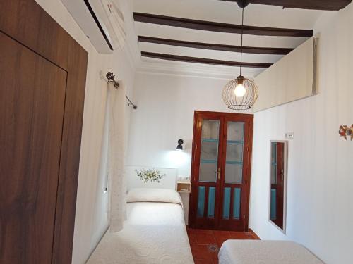 a bedroom with a bed and a wooden door at El DETALLE Apartamento y Estudio in Zahara de la Sierra