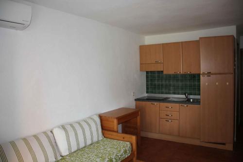 a living room with a couch and a kitchen at Sea & sugar in Linguizzetta