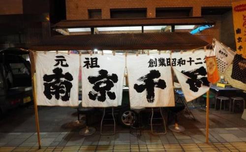 a banner with chinese writing on it in a room at Base605 in Kurume