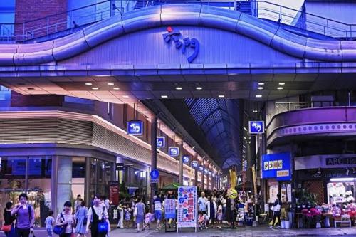 a crowd of people walking in a shopping mall at Base605 in Kurume