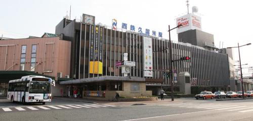 a bus is parked in front of a large building at Base605 in Kurume