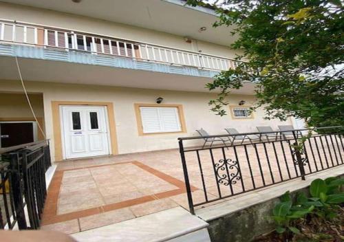 a house with a gate and a porch with chairs at Ολόκληρο σπίτι με 3 υπνοδωμάτια στην Μεσσηνία in Dhórion