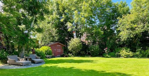 a yard with two chairs and a table in the grass at Sylter Seestern App Hortensie in Morsum