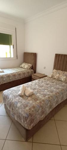 a bedroom with two beds with towels on it at Nour 2 in Oued Laou
