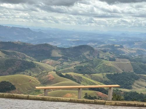 a wooden bench sitting on top of a mountain at Casa na Rampa - Hospedagem no Caravaggio in Santa Teresa