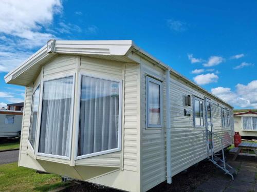 a white caravan with awning and windows at Red Lion Holiday Park in Arbroath