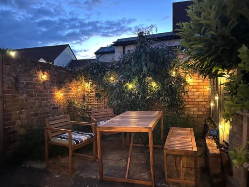 a wooden table and two chairs on a patio at night at Lavender Cottage, Clare in Clare