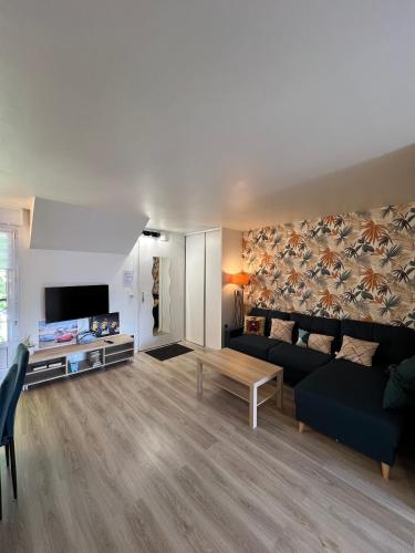 un salon avec un canapé et une table dans l'établissement Appartement Cosy Disneyland, à Magny-le-Hongre