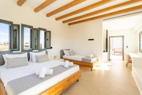 two beds in a room with windows at Regency Sunset Suites in Mýkonos City