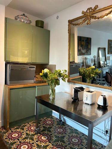 une cuisine avec une table avec un vase de fleurs dessus dans l'établissement Mavisa, à Vincennes