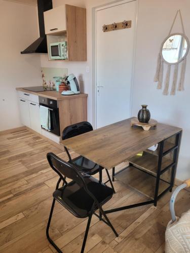 une cuisine avec une table en bois et deux chaises dans l'établissement La cabanista, à Notre-Dame-de-Monts