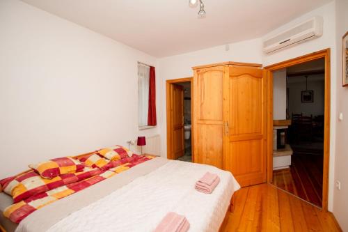 a bedroom with a bed and a wooden cabinet at Levendula Villa in Balatonőszöd