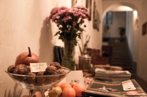 a table with a bowl of nuts and a vase of flowers at Il Vecchio Comune in Santa Sofia