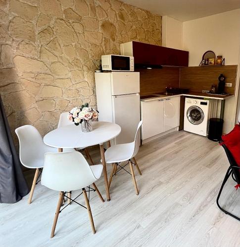a small kitchen with a white table and chairs at Le Clos des Baleines RDC avec jardin et 1 place de parking privée dans un garage in Limoges