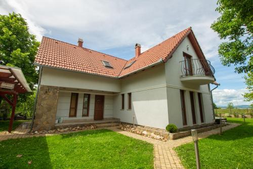 a house with a balcony and a yard at Levendula Villa in Balatonőszöd