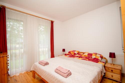 a bedroom with a bed with two towels on it at Levendula Villa in Balatonőszöd