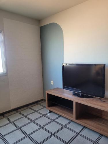 a living room with a flat screen tv on a wooden entertainment center at Apartamento Grande em Itapuã - Vila Velha in Vila Velha