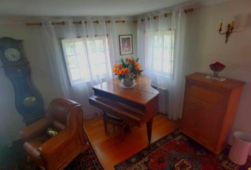 a living room with a piano and a chair at Casa dos Encantos in Arcos de Valdevez