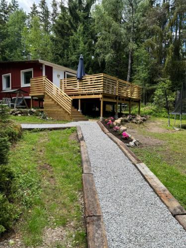a house with a deck with an umbrella on it at Mysig stuga i Nävesta in Örebro