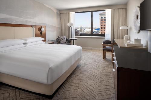 长滩Marriott Long Beach Downtown的配有一张大床和一张书桌的酒店房间