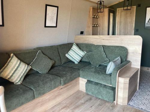a green couch with pillows in a living room at Chapel Fields Holiday Park in Chapel Saint Leonards