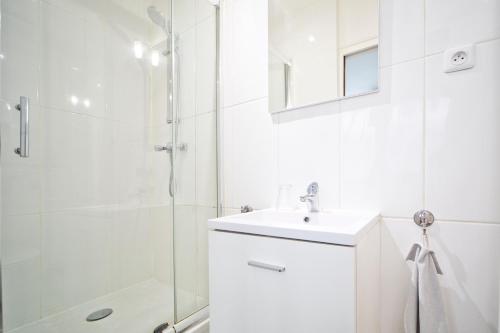 une salle de bain blanche avec un lavabo et une douche dans l'établissement Loft style apartment, à Paris