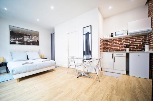 une chambre avec un lit et une table et une cuisine dans l'établissement Loft style apartment, à Paris